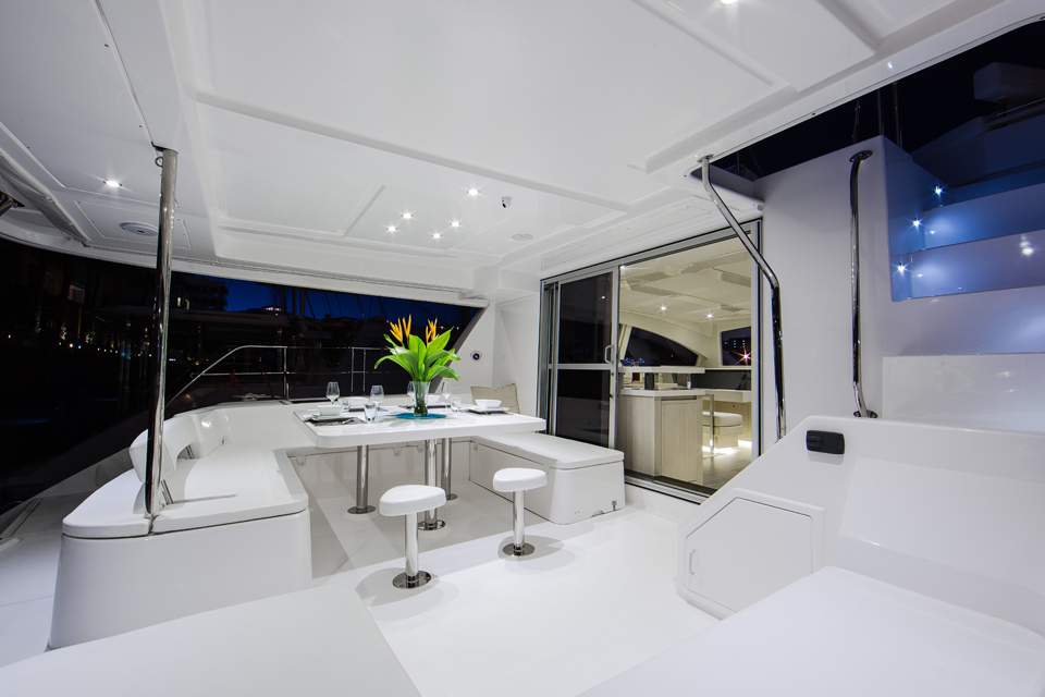 The Leopard 51 Luxury Power Catamaran – Aft cockpit dining table lit at night – Avelis Yachts Singapore