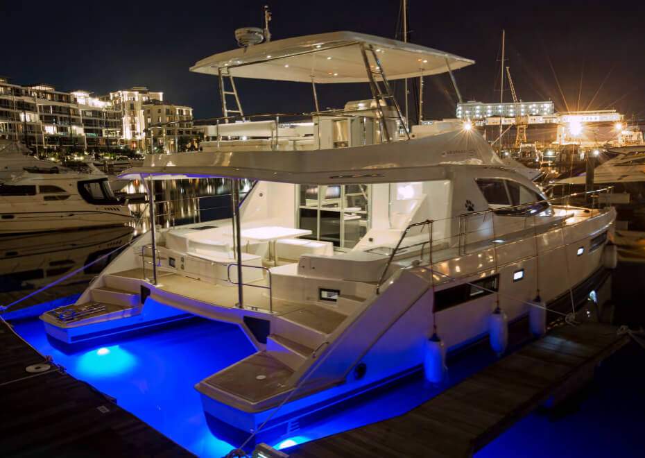 The Leopard 51 Luxury Power Catamaran – Berthed at night with blue underwater lighting – Avelis Yachts Singapore